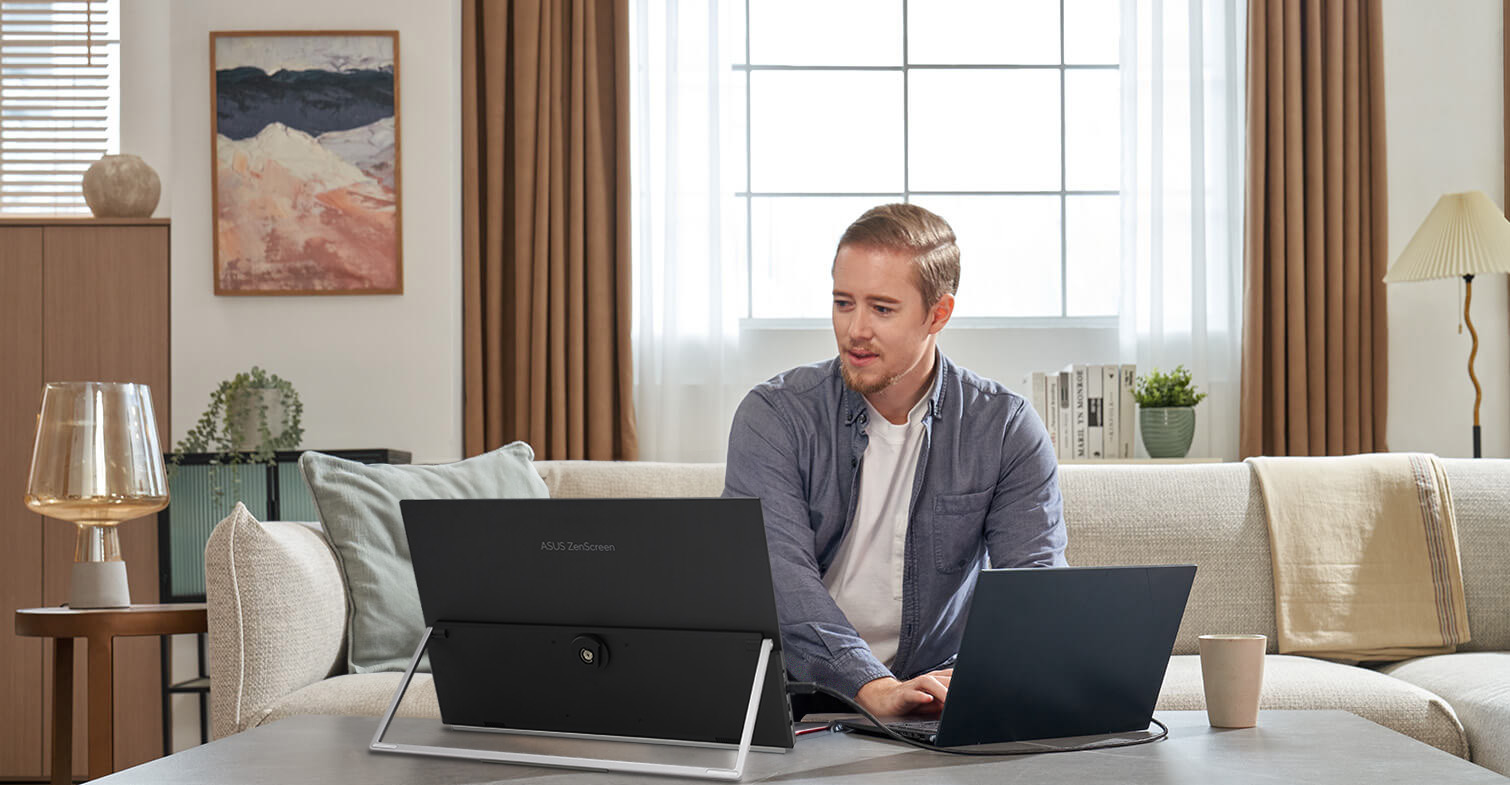 Frontansicht eines Mannes, der von zu Hause aus mit dem ZenScreen MB229CF im Kickstand-Modus am unteren Cafétisch arbeitet