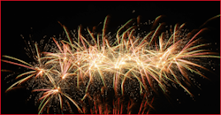 Bild eines Feuerwerks gegen einen dunklen Himmel. / Bild eines Feuerwerks vor einem dunklen Himmel, wobei die Mitte des Feuerwerks abgedunkelt ist.